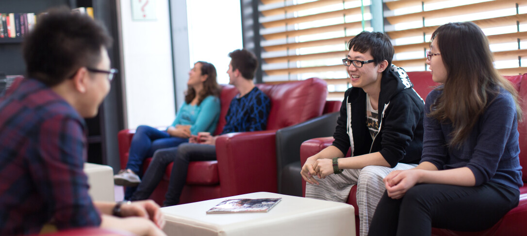 Students sitting in a common room laughing together