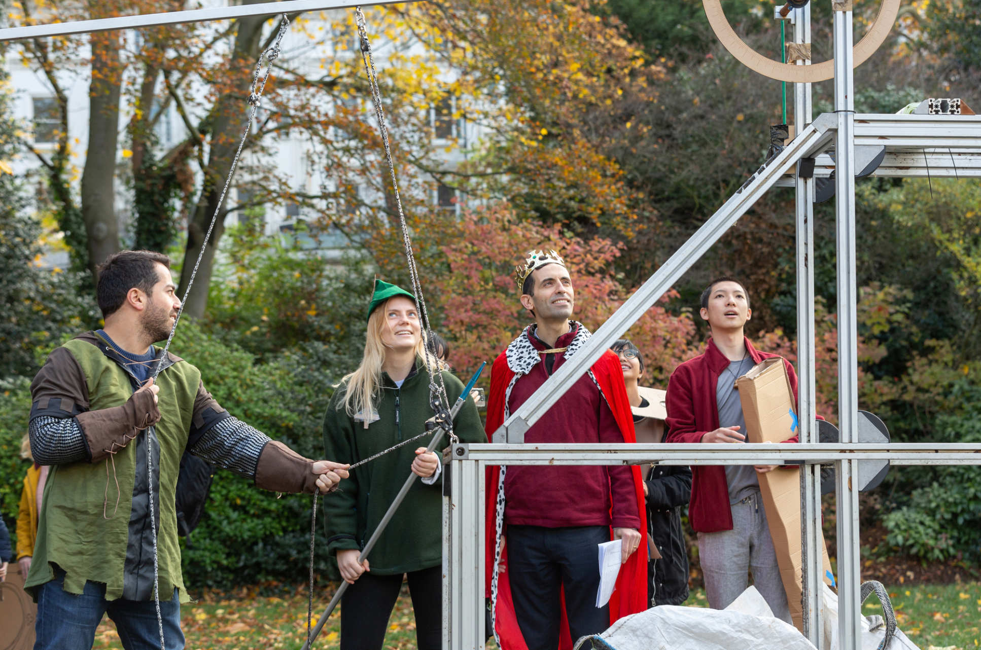 people in costumes looking up at structure