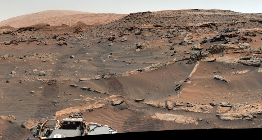 Feòrachas, Gale crater. A mountain can be seen rising in the distance. The rover is recording pictures of the rocks to understand the ancient history of the crater