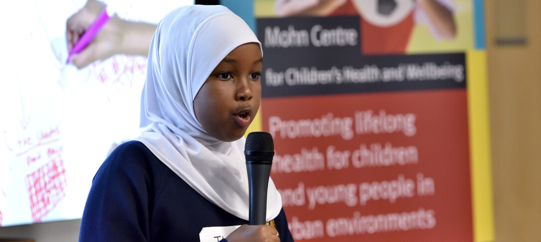 Young girl with hijab speaking into microphone