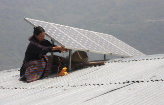 Woman on a roof installing a solar panel