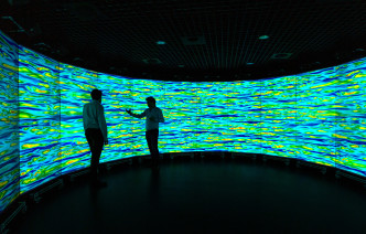 Two people standing in front of an immersive wall
