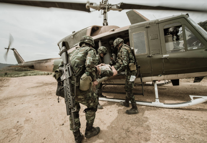 Soldiers carrying an injured soldier into a helicopter