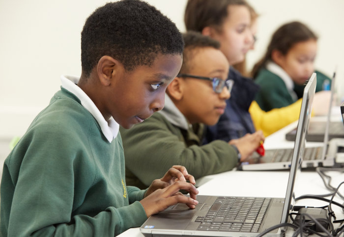 young boy coding on a laptop