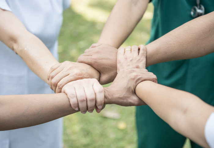 Hands of healthcare workers connected in a circle