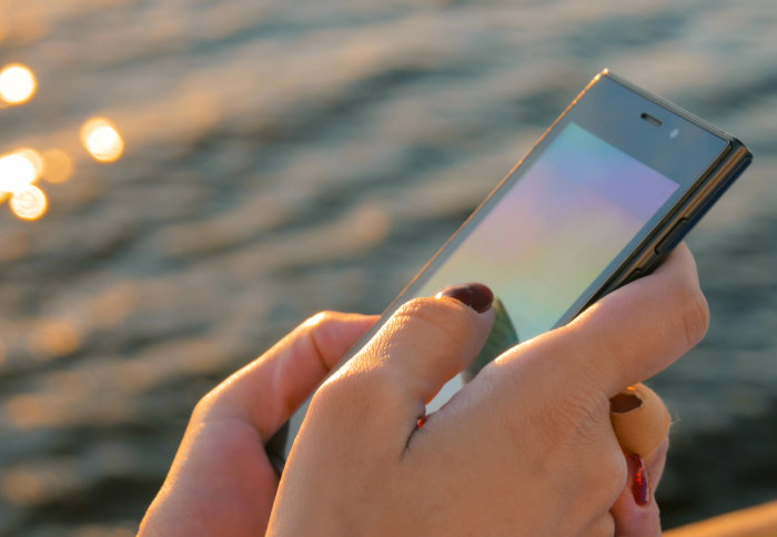 Person holding a smartphone on a sunny day