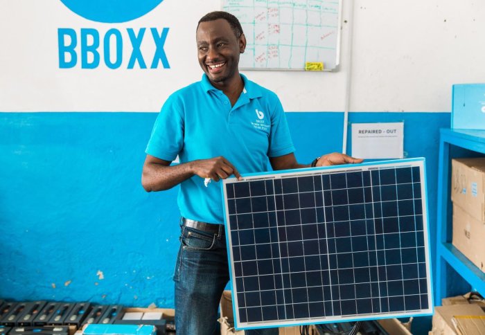 A member of the Bboxx team with a solar panel