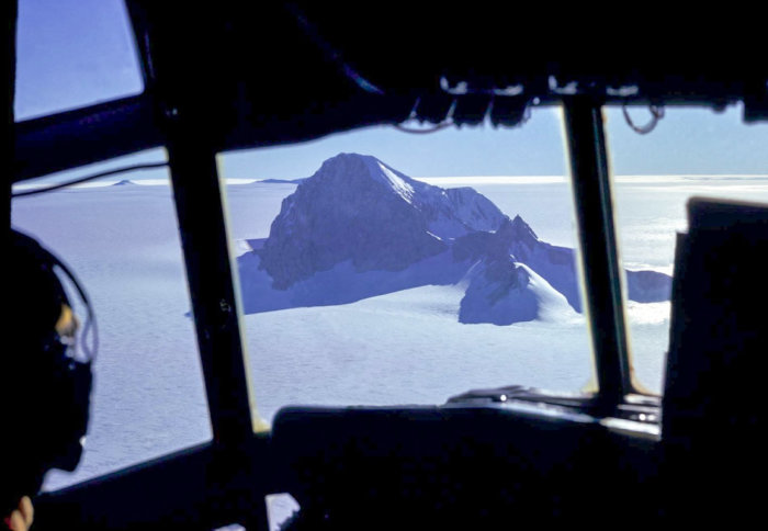 View of a mountain peak through ice from a plane cockpit