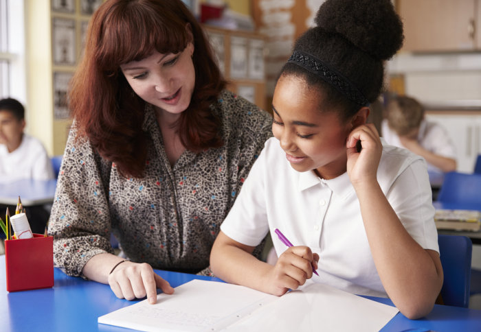 A student and teacher look at a jotter