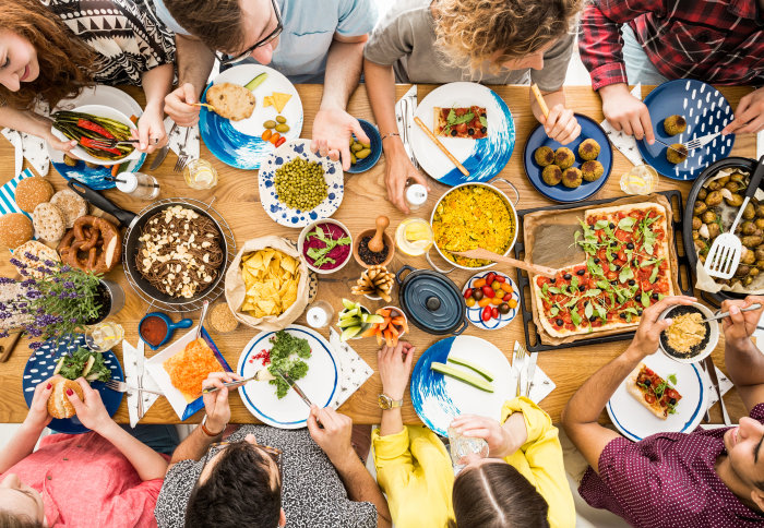 Birds-eye view of people around a table of plant-based foods