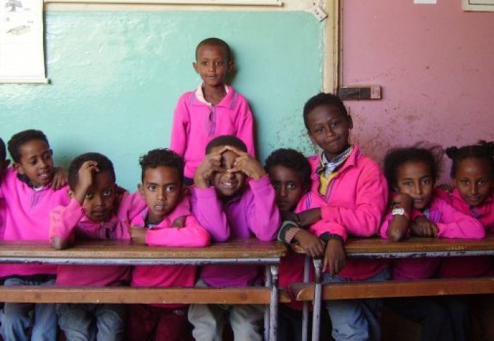 Group of children in a school who receive food from Partnership for Child Development