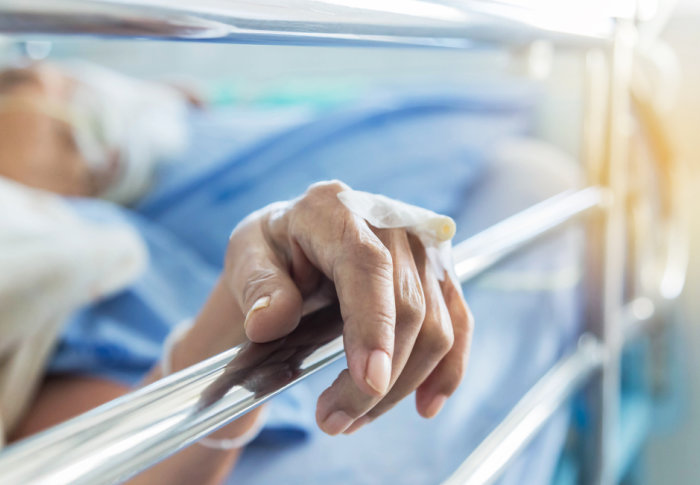 Hand of an elderly patient in a hospital bed