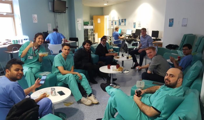 NHS staff eat food together and smile at camera