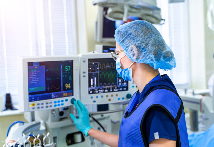 A female health professional operating a ventilator