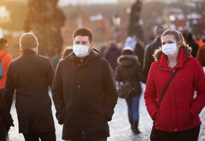 Two people in masks walking in the street