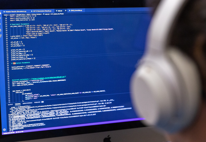 A computing student is shown working on code in a computing lab