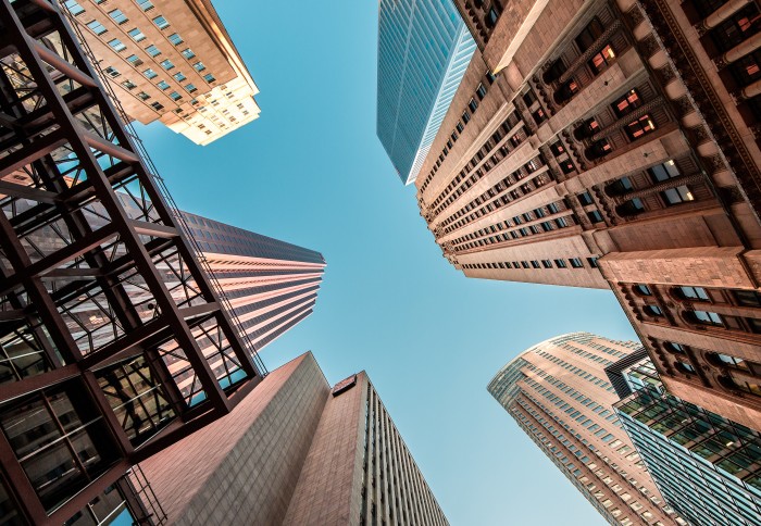 An upward shot of sky scrappers against a blue sky