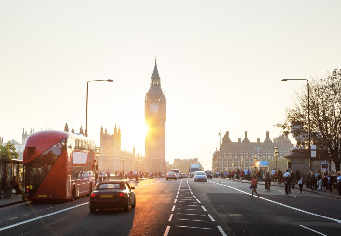 Houses of Parliament in London at sunset with cars and Bus on bridge