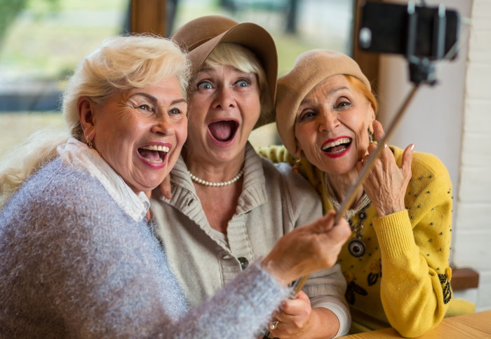 Elderly women embracing and smiling, taking a photo