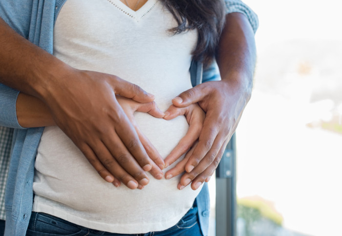 Couple's hands on pregnant stomach