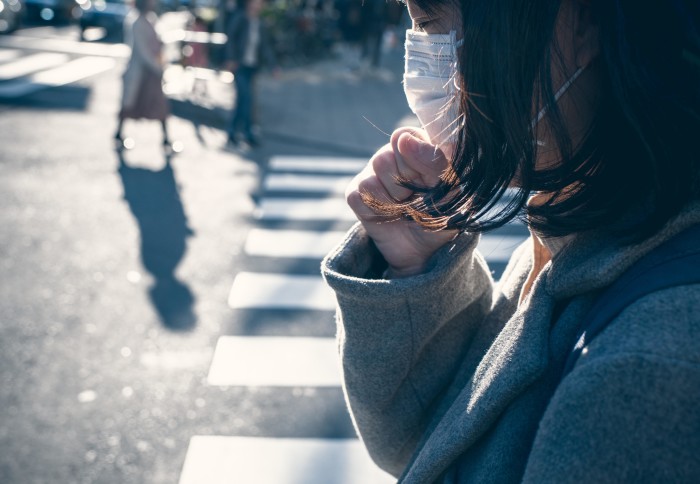 A woman with a facemask on a roadside