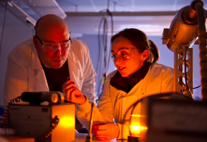 Professor Oscar Ces with Research Postgraduate Hanna Barriga, in a laboratory, examining a sample prepared for analysis on a small-angle X-ray scattering beamline.