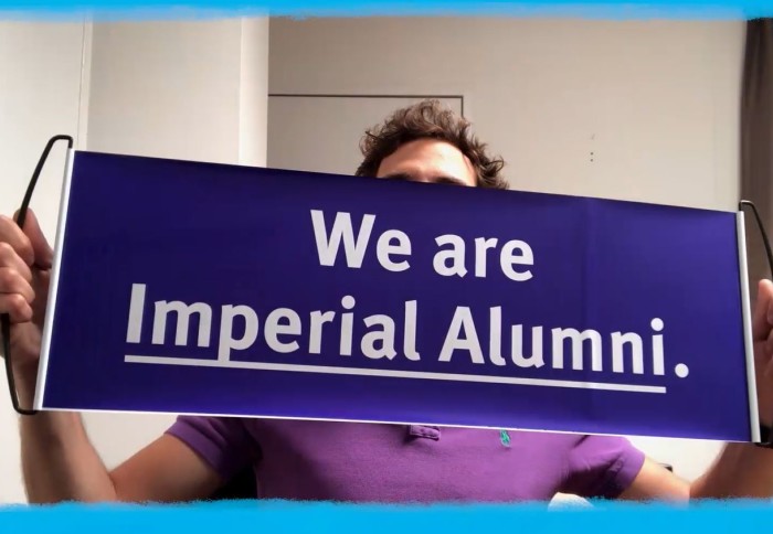 Alumnus Sasha in New York holds up a banner reading 'We are Imperial alumni'