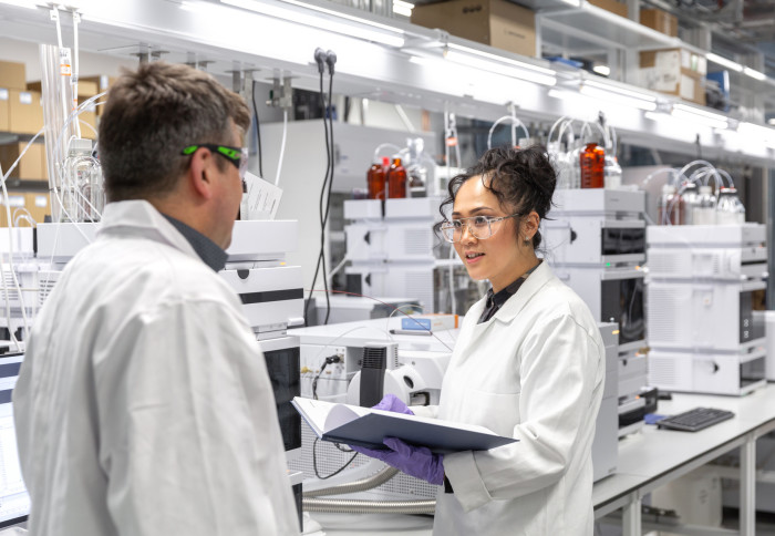 Two people in front of analytical science equipment in the Agilent Measurement Suite