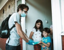 Donated laptop being delivered on the doorstep to two children