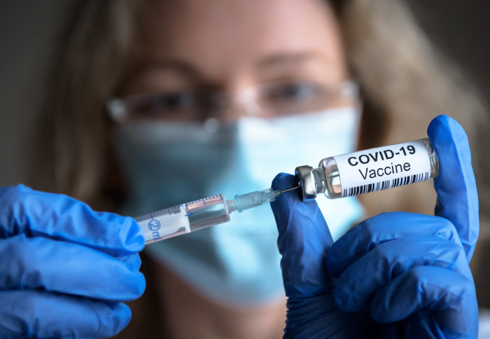 Scientists holds container with 'COVID-19 vaccine' written on it