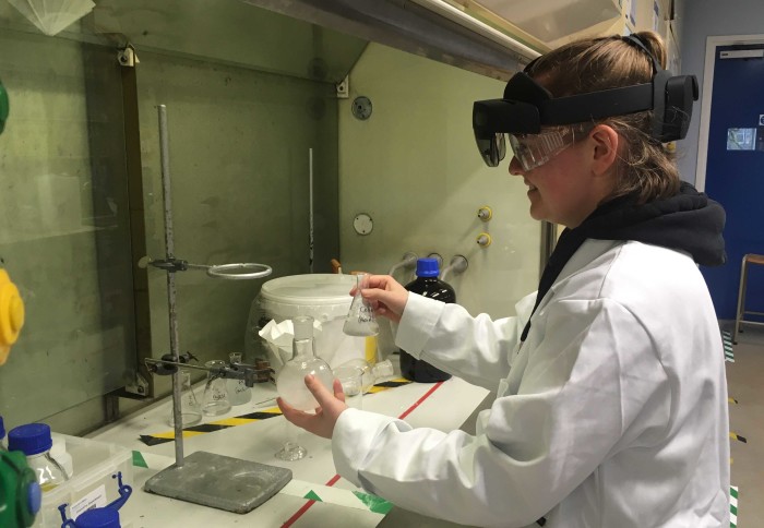 Chemistry laboratory assistant wearing a Hololens whilst doing experiment