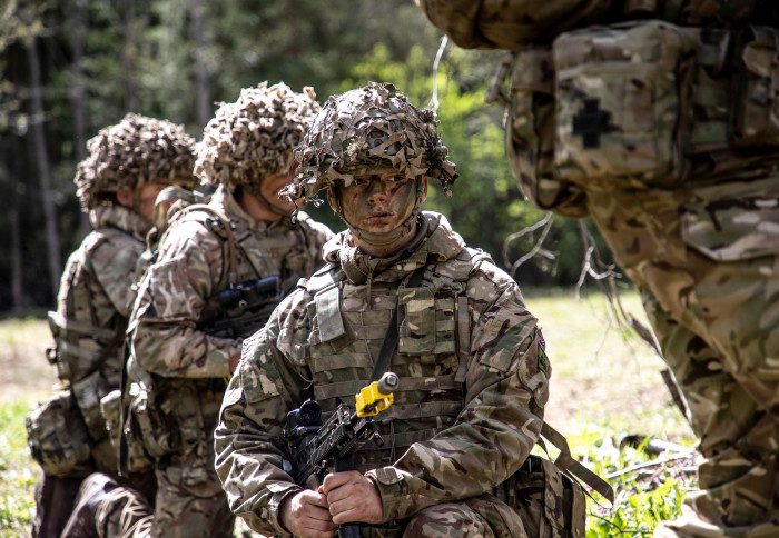 Members of the British Army infantry wearing camouflage and preparing to participate in a military exercise
