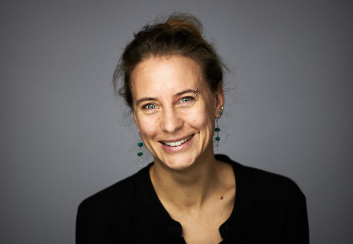 Portrait photo of Dr Otto, a white woman in her 30s with brown hair tied up on her head, she wears a smart black jacket