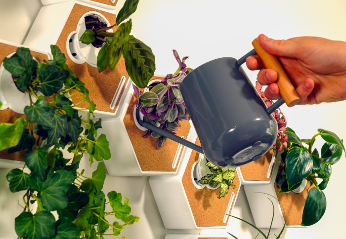 A hand holding a watering can