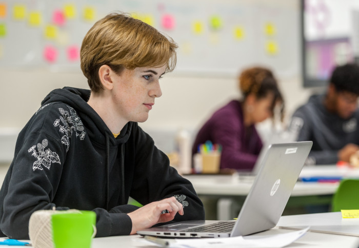 Young woman using a laptop in a classroom