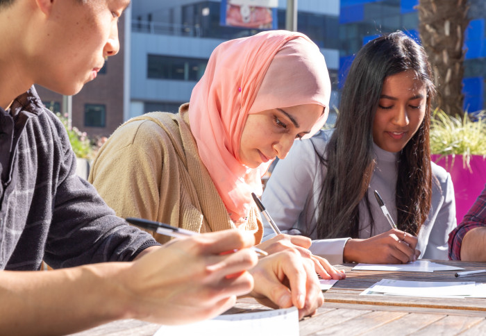 Three students writing