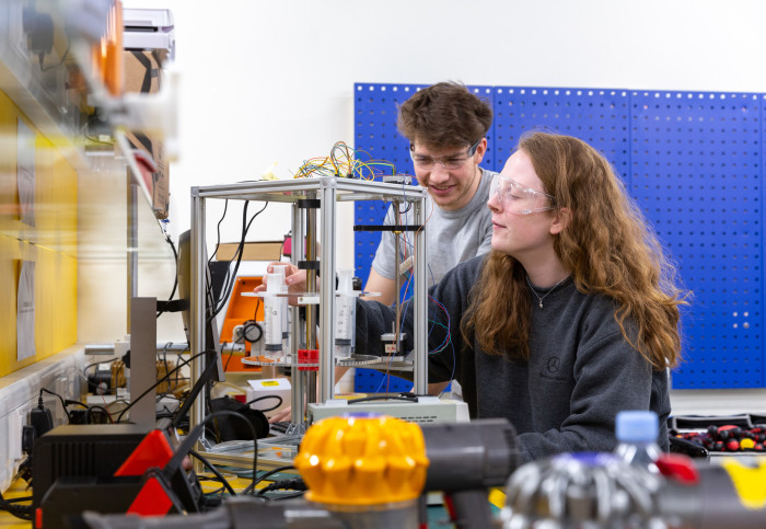 Two students in Imperial College Advanced Hackspace using equipment