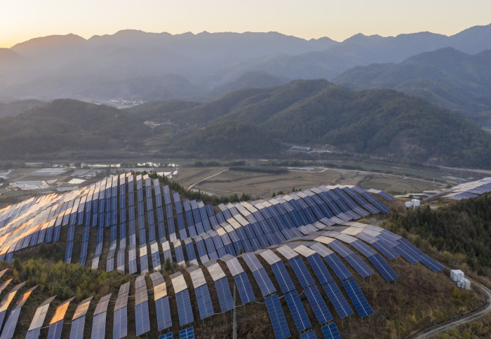 The golden winter sun shines on the solar panels on the mountain