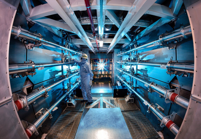 Person in protective clothing works in nuclear chamber