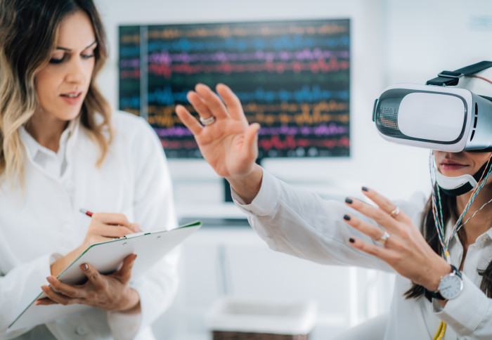 A doctor with a patient who is wearing a VR headset