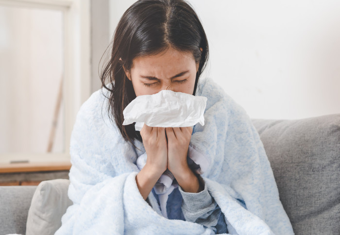 A woman sneezing after catching the common cold
