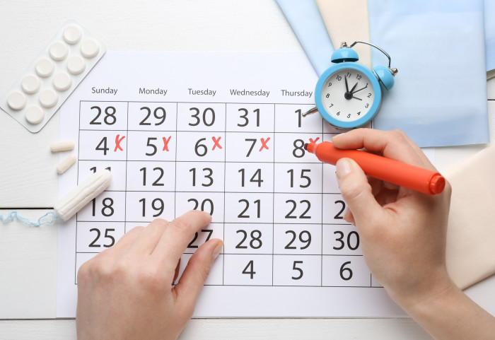 Menstrual pads and tampons on menstruation period calendar