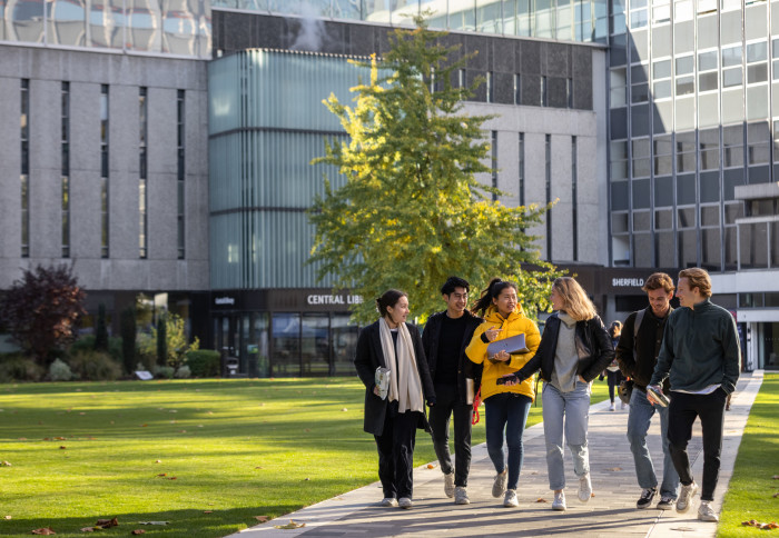 Group of six people walking across the Queen's Lawn