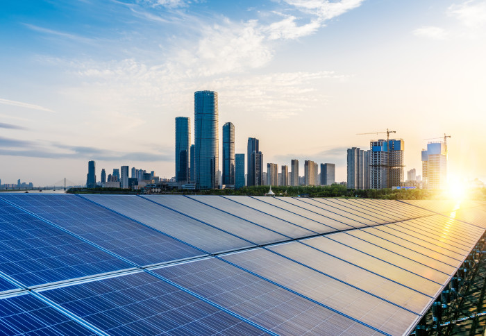 Solar panels with a city skyline in the background