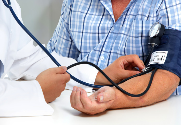 A man has his blood pressure checked by a doctor.