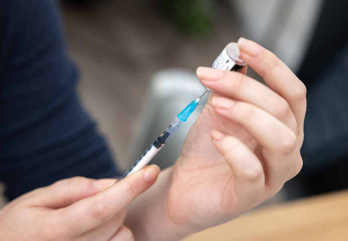 A volunteer prepares a COVID-19 vaccine dose.