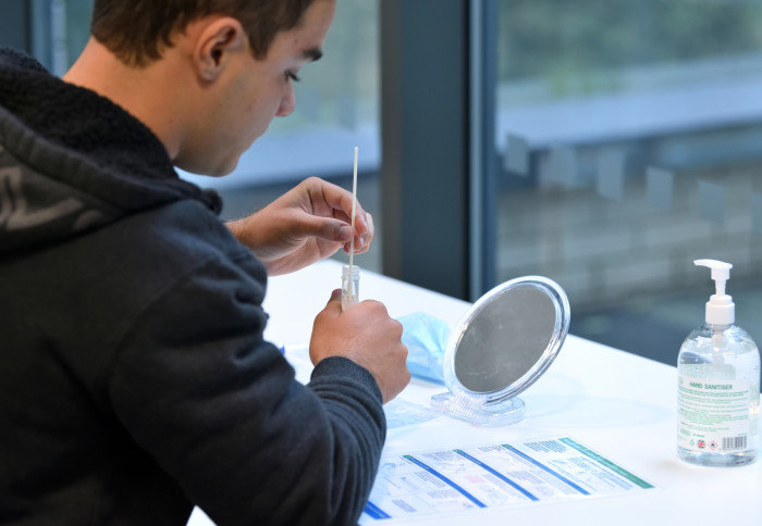 A student at Imperial College London takes a test for COVID-19 infection.