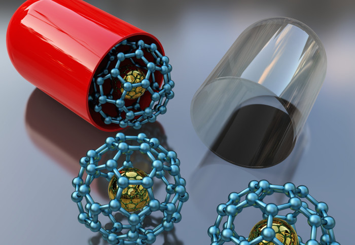 Conceptual illustration showing a modified-release dosage capsule containing C60 buckyballs doped with another atom.