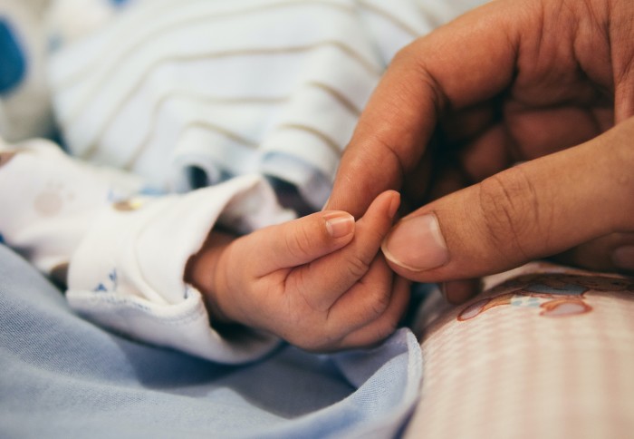 Person holding child's hand