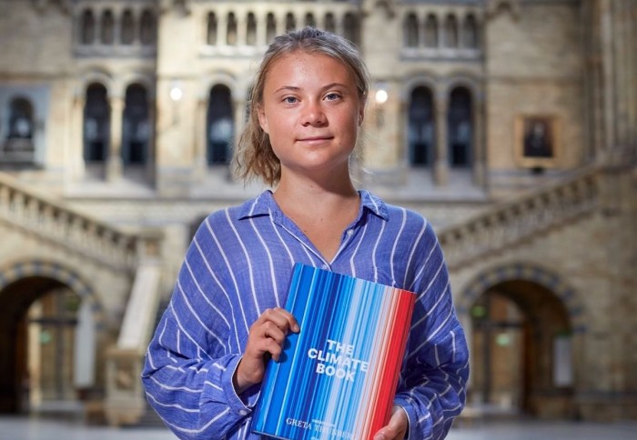 Greta Thunberg holding "The Climate Book"